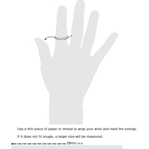 K&ouml;nnte beinhalten: Diagramm, das zeigt, wie man sein Handgelenk f&uuml;r ein Armband misst. Verwenden Sie ein d&uuml;nnes St&uuml;ck Papier oder Garn, um Ihr Handgelenk zu umwickeln und den &Uuml;berlapp zu markieren. Wenn das Papier oder Garn nicht eng anliegt, wird eine gr&ouml;&szlig;ere Gr&ouml;&szlig;e gemessen. Das Diagramm zeigt ein Lineal mit einer Messung von 58 mm.