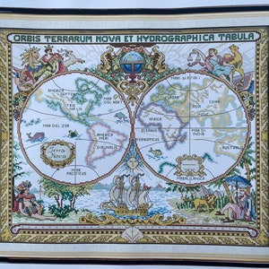 May include: A cross-stitch embroidery of a vintage world map with the title "Orbis Terrarum Nova et Hydrographica Tabula". The map is divided into two hemispheres, with the Americas on the left and Europe, Asia, and Africa on the right. The map is surrounded by a decorative border.