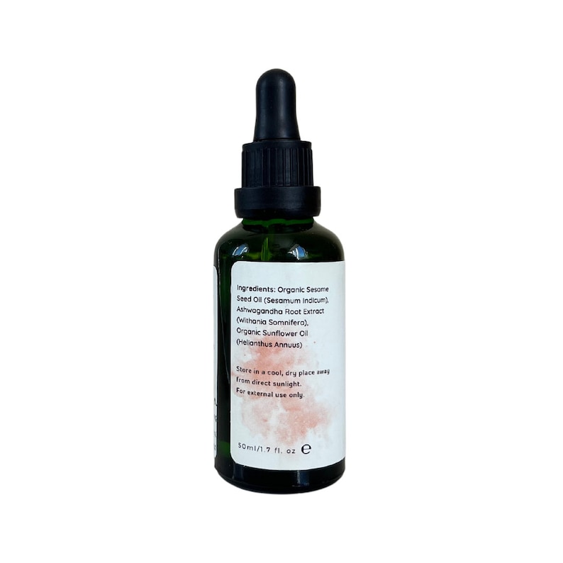 May include: A green glass bottle with a black dropper top. The bottle contains a clear liquid and has a white label with the text "Ingredients: Organic Sesame Seed Oil (Sesamum Indicum). Ashwagandha Root Extract (Withania Somnifera). Organic Sunflower Oil (Helianthus Annuus) Store in a cool, dry place away from direct sunlight. For external use only 50ml/1.7 fl. oz e"