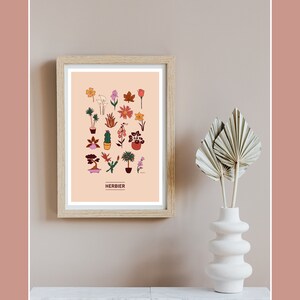 Puede incluir: Una impresi&oacute;n enmarcada con un fondo melocot&oacute;n y una colecci&oacute;n de 24 plantas y flores ilustradas. La impresi&oacute;n est&aacute; titulada "HERBIER" en texto negro.