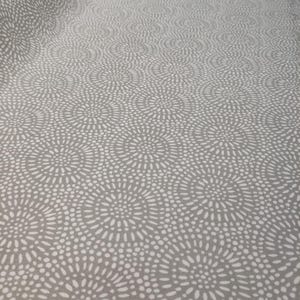 Könnte beinhalten: Grauer Stoff mit einem sich wiederholenden Muster aus weißen, gepunkteten, kreisförmigen Designs. Das Muster ähnelt stilisierten Blumen oder Ausbrüchen und erzeugt ein strukturiertes Aussehen auf dem Material. Der Stoff hat einen weichen, fließenden Fall.