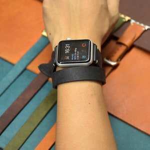 May include: A silver Apple Watch with a black leather band on a wrist. The watch face displays the time 16:31, the date 30 May, and the day of the week, Thursday.