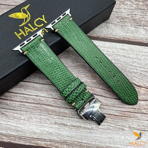 May include: Green leather watch band with a silver buckle. The band has a textured, alligator-like pattern. The band is on a black box with the word "HALCY" printed on it.