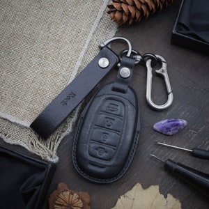 May include: Black leather key fob with a silver key ring and a black leather strap with the word "Rock" embossed on it.