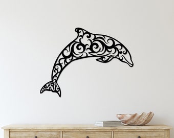 May include: Black metal wall art featuring a stylized dolphin with intricate swirling patterns. The dolphin is leaping out of the water and is mounted on a white wall above a wooden console table.