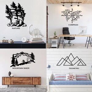 May include: Four wall art pieces with black silhouettes. The top left shows trees and rocks with the word "NATURE". The top right shows a compass and world map with the word "COMPASS". The bottom left shows a mountain skier with the words "MOUNTAIN SKIER". The bottom right shows geometric mountains with the word "GEOMETRIC".