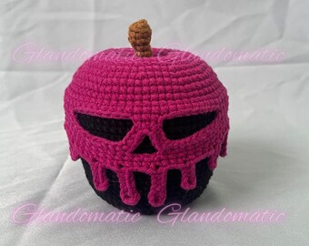 May include: A crocheted apple-shaped decoration in black and magenta, featuring a skull design on the front. The stem is brown. The apple is a handmade item, perfect for Halloween or spooky decor.