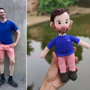May include: A crocheted doll with a blue shirt, pink pants, and a brown beard. The doll is holding a small blue ball.