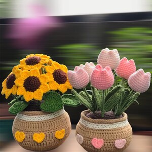 Peut inclure: Deux arrangements floraux en crochet dans des pots. Un pot a des tournesols jaunes et l'autre a des tulipes roses.