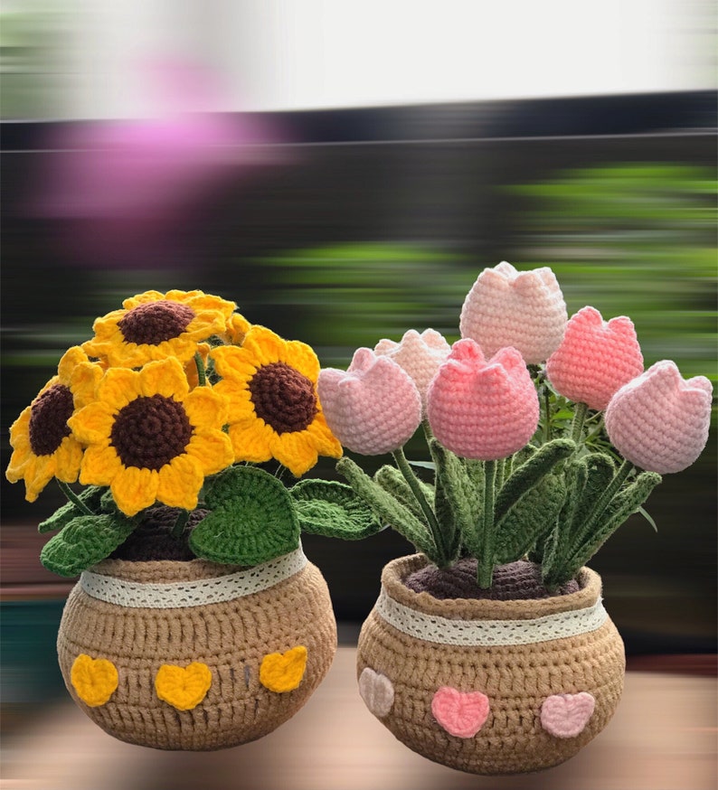 Peut inclure: Deux arrangements floraux en crochet dans des pots. Un pot a des tournesols jaunes et l'autre a des tulipes roses.