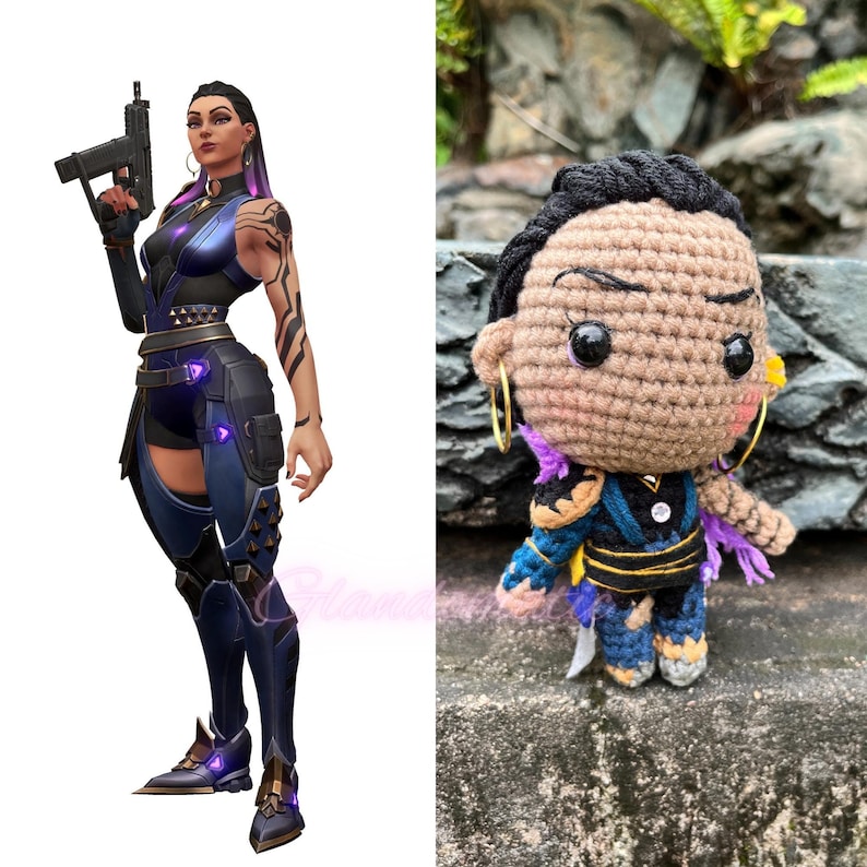 Pu&ograve; includere: Una bambola amigurumi all'uncinetto di un personaggio femminile con la pelle marrone, i capelli neri e vestiti viola e gialli. La bambola ha grandi occhi neri e un design all'uncinetto.