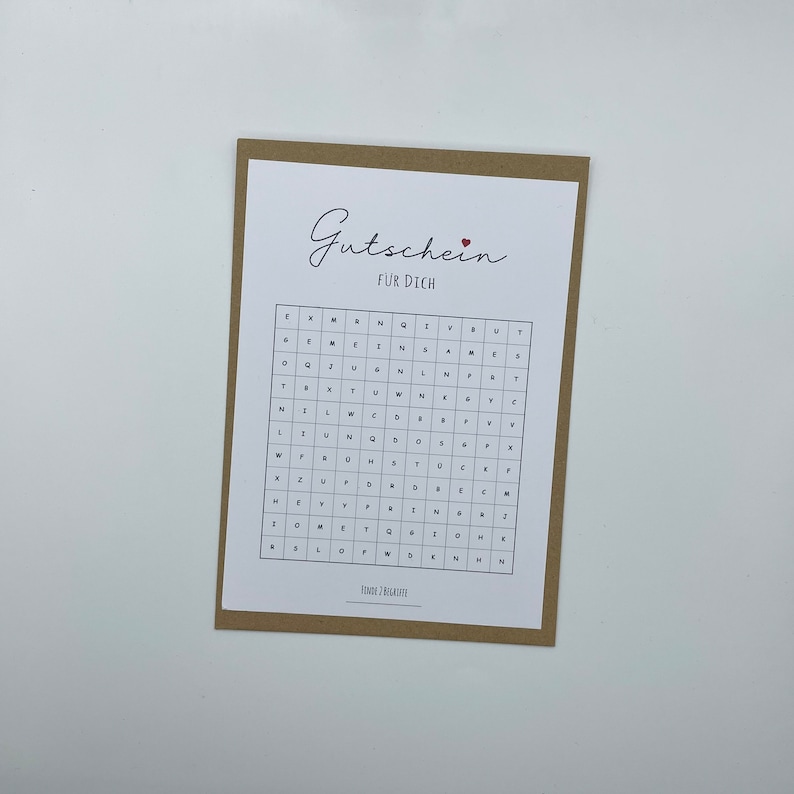 May include: A white card with brown trim features a word search puzzle with the text "Gutschein f&uuml;r Dich" at the top. The puzzle is filled with letters and the word "Gutschein" is highlighted.
