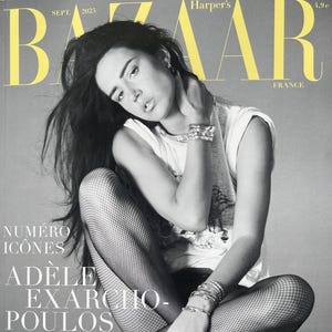 May include: Black and white cover of Harper's Bazaar France, September 2025 issue. Features a woman with dark hair, wearing a white top and fishnet stockings. The cover includes the text "NUMÉRO ICÔNES" and "ADÈLE EXARCHO-POULOS".
