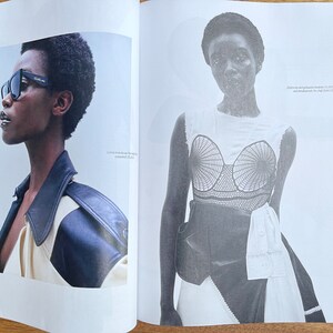 Puede incluir: Dos mujeres aparecen en un editorial de revista. La mujer de la izquierda lleva una chaqueta de cuero negra y gafas de sol. La mujer de la derecha lleva un top blanco con un corpi&ntilde;o de crochet negro y un cintur&oacute;n negro. El texto "ELLE 63" es visible en la esquina inferior derecha de la imagen.