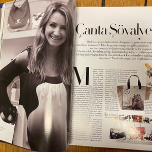 May include: A magazine spread featuring a black and white photo of a woman with long hair, wearing a black and white top. The magazine article is about handbags and features the text "&Ccedil;anta Ş&ouml;valyesi" and "I'm not a plastic bag".