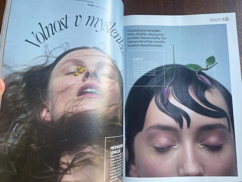 May include: A magazine spread features two close-up portraits. One shows a person with eyes closed, a flower on their nose, and the text "Volnost v my&scaron;lenke." The other shows a person with styled hair and the text "SLEEKY."