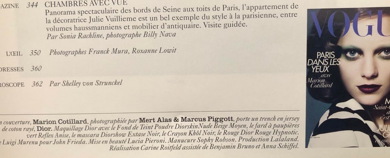 以下が含まれることがあります： 濃い色の髪と劇的なメイクをした女性が写っている雑誌の表紙。雑誌はヴォーグで、表紙のテキストは「パリ・ダン・レ・ジュー」と「マリオン・コティヤール」が書かれている。
