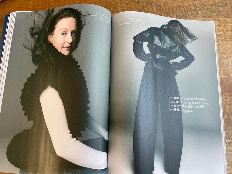 May include: A fashion magazine spread featuring a woman wearing a black, textured shawl over a white long-sleeved top. The other image shows a person in a black leather jacket, wide-leg pants, and a belt. The background is a light gray.