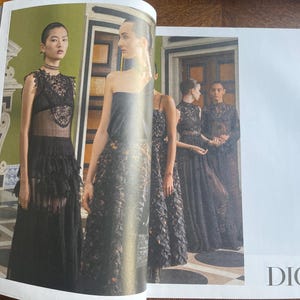 May include: A fashion editorial featuring models in black gowns with lace and floral detailing. The models are posed in a room with green walls and ornate architectural details. The word "DIOR" is visible.