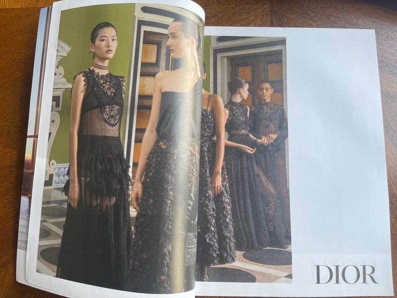 May include: A fashion editorial featuring models in black gowns with lace and floral detailing. The models are posed in a room with green walls and ornate architectural details. The word "DIOR" is visible.