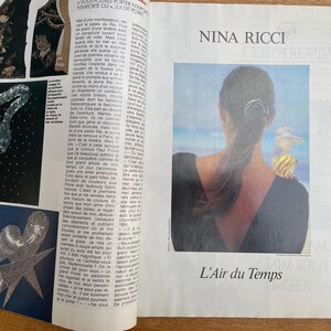 May include: A magazine spread featuring fashion and perfume advertisements. One ad showcases a woman with her back to the viewer, with a perfume bottle on her shoulder. The text "NINA RICCI" and "L'Air du Temps" are visible.