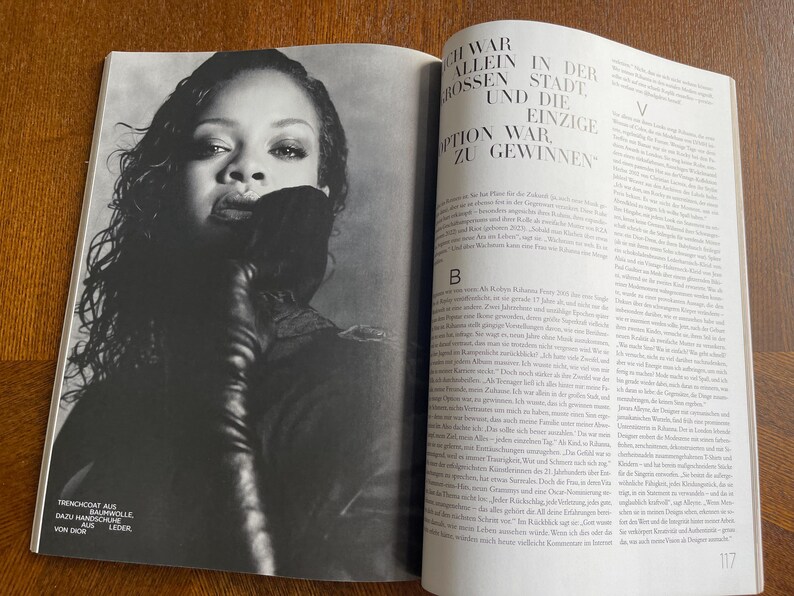 Puede incluir: P&aacute;gina de revista en blanco y negro con una mujer de pelo oscuro y un guante de cuero. El texto en el lado izquierdo de la p&aacute;gina dice: "TRENCHCOAT AUS BAUMWOLLE DAZU HANDSCHUHE AUS LEDER VON DIOR."