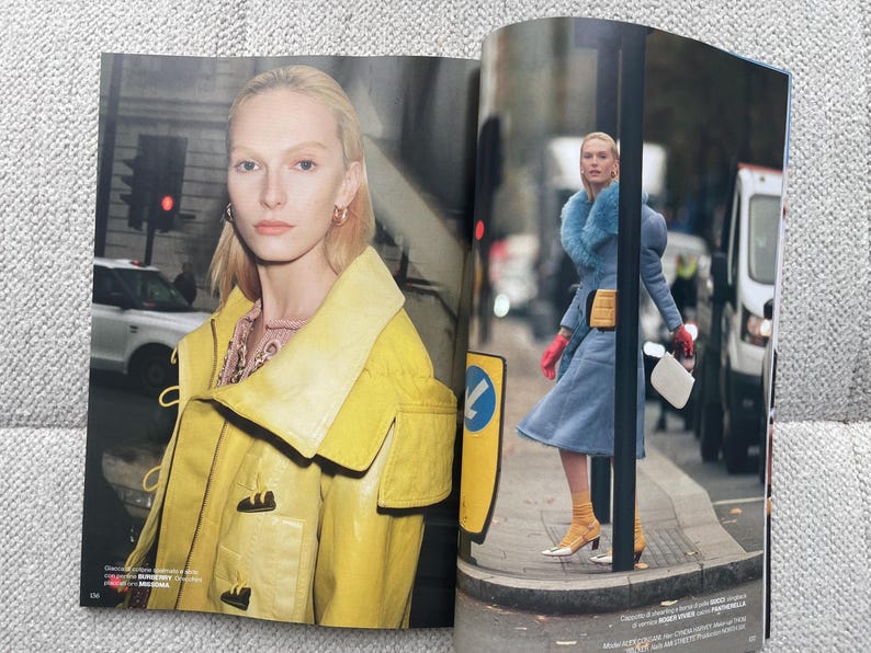 Puede incluir: Una revista de moda con una mujer con una chaqueta amarilla y otra con un abrigo azul con cuello de piel. Una est&aacute; frente a un sem&aacute;foro, la otra camina por una calle.