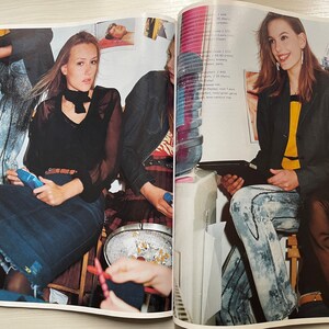 May include: Three women wearing different styles of clothing. One woman is wearing a black top with a white collar and a denim skirt. Another woman is wearing a black blazer with a yellow top and denim jeans. The third woman is wearing a black top with a denim skirt.