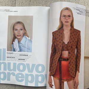 Puede incluir: Una p&aacute;gina de revista de moda con una modelo luciendo una blazer marr&oacute;n con estampado floral, combinada con un top corto a juego y una falda naranja. El texto "nuovo preppy" se muestra en letras grandes de color azul claro. Una imagen m&aacute;s peque&ntilde;a muestra a una modelo con una camisa azul claro.