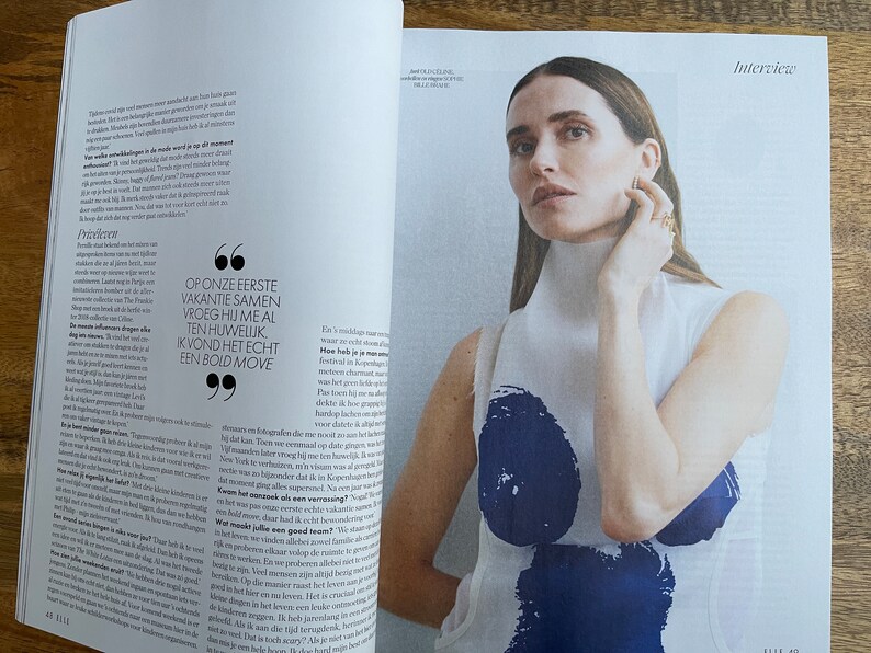 Puede incluir: Una mujer con el pelo largo y casta&ntilde;o lleva una blusa blanca sin mangas con un dise&ntilde;o abstracto azul. El texto "Interview" est&aacute; en la esquina superior derecha de la imagen. El texto "OP ONZE EERSTE VAKANTIE SAMEN VROEG HIJ ME AL TEN HUWELIJK IK VOND HET ECHT EEN BOLD MOVE" est&aacute; en un bocadillo.