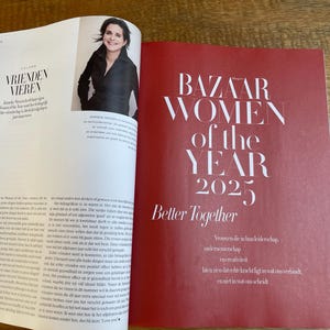 May include: A magazine spread featuring a woman's portrait and text. The right page has a red background with the text "BAZAAR WOMEN of the YEAR 2025 Better Together". The left page has text in a different language.