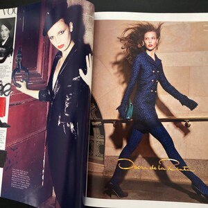 以下が含まれることがあります： 異なる服装と靴を履いた2人の女性。左側の女性は黒い革のジャケットと黒い帽子を着用しています。右側の女性は青いジャケットと黒いタイツを着用しています。画像の右下隅に「Oscar de la Renta」というテキストが表示されています。