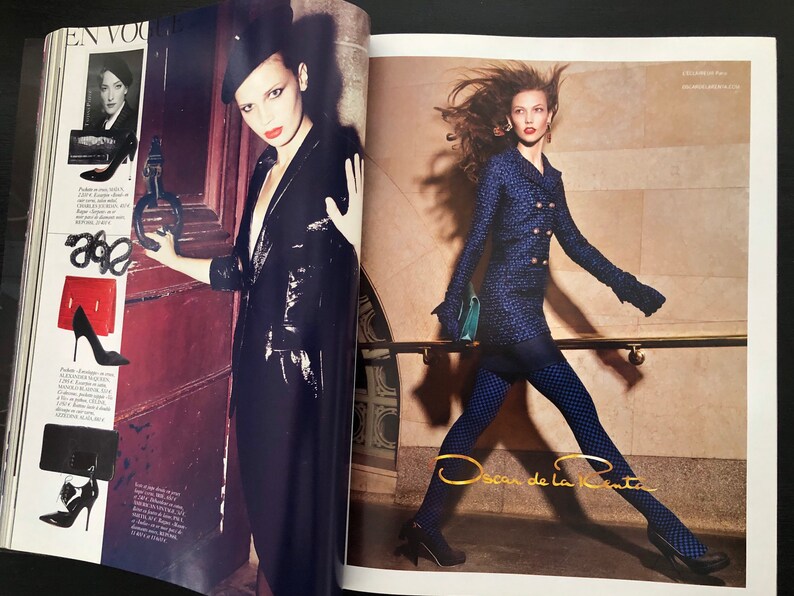 以下が含まれることがあります： 異なる服装と靴を履いた2人の女性。左側の女性は黒い革のジャケットと黒い帽子を着用しています。右側の女性は青いジャケットと黒いタイツを着用しています。画像の右下隅に「Oscar de la Renta」というテキストが表示されています。
