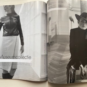 May include: Two women in black and white photos. The woman on the left is wearing a black leather jacket and a white skirt. The woman on the right is wearing a black blazer, a silver skirt, and a black hat. The text "Museumcollectie" is printed on the page.