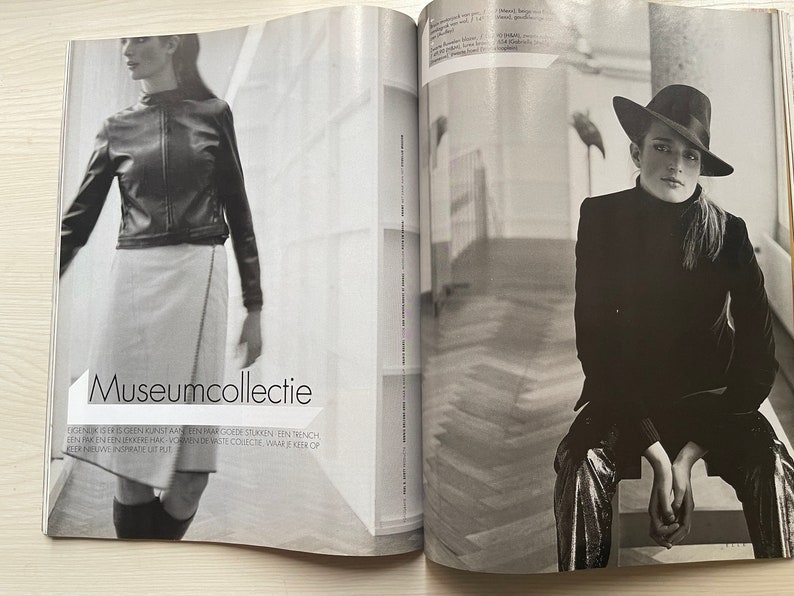 May include: Two women in black and white photos. The woman on the left is wearing a black leather jacket and a white skirt. The woman on the right is wearing a black blazer, a silver skirt, and a black hat. The text "Museumcollectie" is printed on the page.