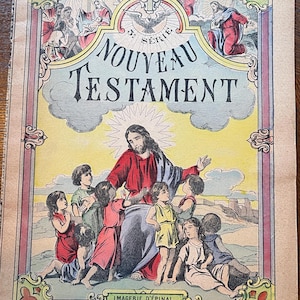 May include: A vintage illustrated book cover featuring a yellow background with a depiction of Jesus Christ surrounded by children. The title reads "Nouveau Testament" with a decorative border and the text "Imagerie d'Epinal Fondée en 1796".