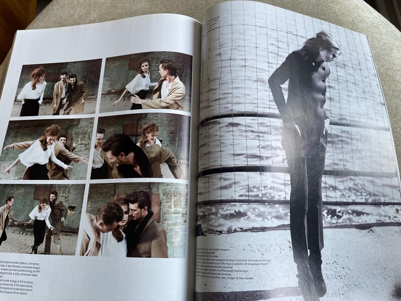 May include: A magazine spread featuring a fashion editorial. The left page shows a series of six small images of a couple interacting with other people. The right page features a full-length silhouette of a person standing near water.