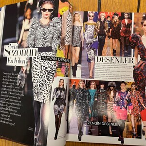 May include: A magazine spread showcasing fashion models wearing clothing with animal print and geometric patterns. The text on the page reads "Yeni Sezonun En İvileri" and "HAYVAN DESENLER" in Turkish. The text also reads "DESENLER" and "ZENGİN DESENLER" in Turkish.