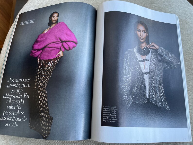 Puede incluir: Una revista de moda con una modelo con un su&eacute;ter magenta vibrante con mangas voluminosas y pantalones estampados. El texto de la p&aacute;gina izquierda dice: &laquo;Es dif&iacute;cil ser valiente, pero es una obligaci&oacute;n.&raquo;