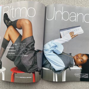 Puede incluir: Una revista de moda de doble p&aacute;gina con los t&iacute;tulos "Ritmo" y "Urbano". Una p&aacute;gina muestra a una persona con un atuendo gris, zapatos negros y calcetines grises. La otra p&aacute;gina presenta a una persona con una chaqueta gris y una camisa azul claro, sosteniendo un cuaderno.