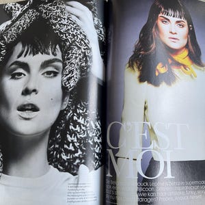 May include: A black and white fashion magazine spread featuring a woman with dark hair and makeup. The left page shows a close-up of the woman with a knitted head covering. The right page features the woman in a cream-colored top and black skirt, with the text "C'EST MOI".
