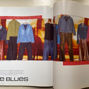 May include: A magazine spread featuring denim clothing, including jackets, shirts, and jeans. The text on the page reads "De Blues" and "Jeanshopping".
