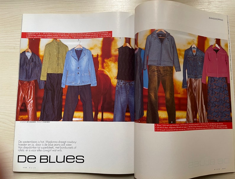 May include: A magazine spread featuring denim clothing, including jackets, shirts, and jeans. The text on the page reads "De Blues" and "Jeanshopping".