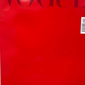 Puede incluir: Una portada de revista roja con la palabra "VOGUE" en letras grandes y oscuras en la parte superior. La palabra "ITALIA" est&aacute; debajo. El fondo es rojo liso.