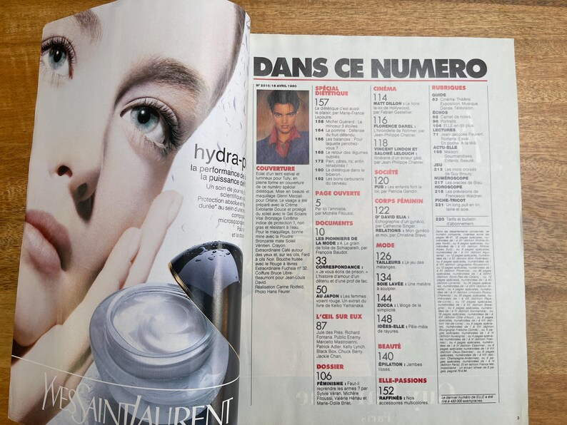 May include: Magazine spread featuring a close-up of a woman's face with blue eyes, promoting Yves Saint Laurent skincare. The text "hydra-p" and "Yves Saint Laurent" are visible. The magazine's title is "DANS CE NUMERO".