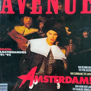 Puede incluir: Una portada de revista con el título "AVENUE" en letras rojas. La portada presenta un retrato de una persona que lleva un sombrero negro y una camisa blanca con cuello. El texto "AMSTERDAM!" está en letras rojas y el texto "GRATIS: AMSTERDAMGIDS 91/'92" está en letras negras.