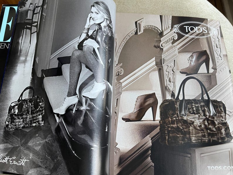 May include: Black and white fashion magazine spread featuring a woman in high heels and a handbag. The magazine also displays a handbag and ankle boots. The Tod's logo is visible.
