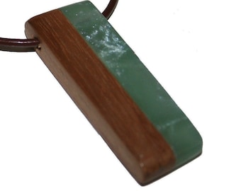 May include: A green and brown rectangular pendant necklace with a leather cord.