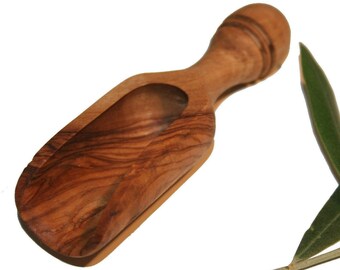 May include: A wooden olive wood scoop with a natural wood grain finish. The scoop is shaped like a small shovel with a rounded handle.