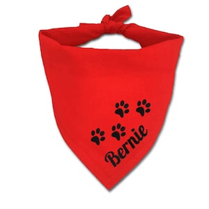 May include: Red bandana with black paw prints and the name "Bernie" embroidered on it.